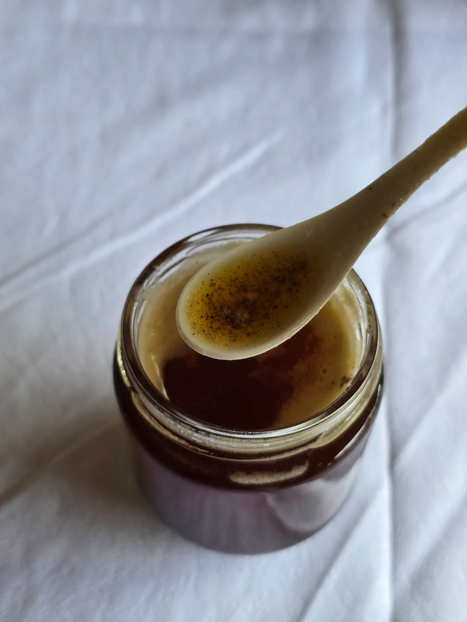 Golden browned butter cooling in a glass jar.